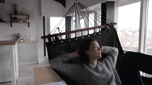 A Woman Resting In A Hammock Indoor