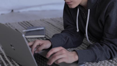 A Woman Typing on a Laptop