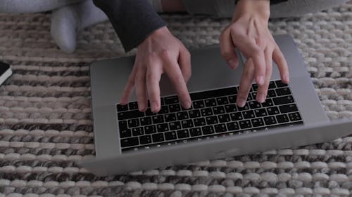 A Woman Typing on a Laptop Keyboard