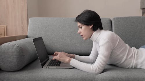 A Woman Typing on a Laptop Keyboard