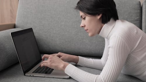 A Woman Typing on a Laptop Keyboard