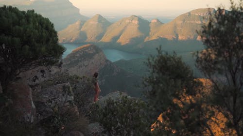 A Woman Sitting on the Edge of a Cliff