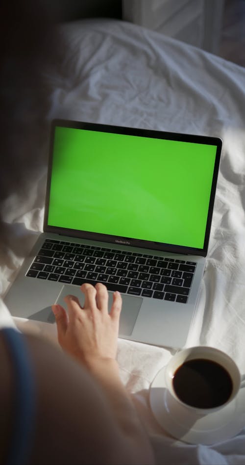 A Woman Using Her Laptop In Bed