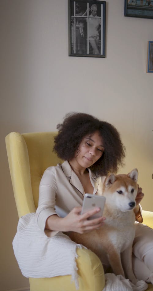 A Woman In Her Pajama Taking Selfie Photo With Her Dog