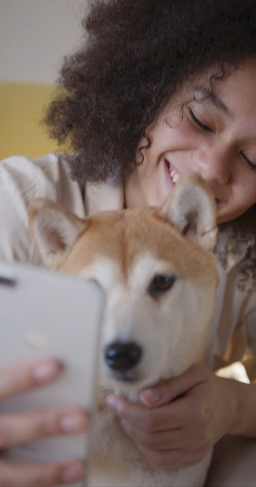 A Woman Using A Mobile Camera Taking Selfie With Her Dog