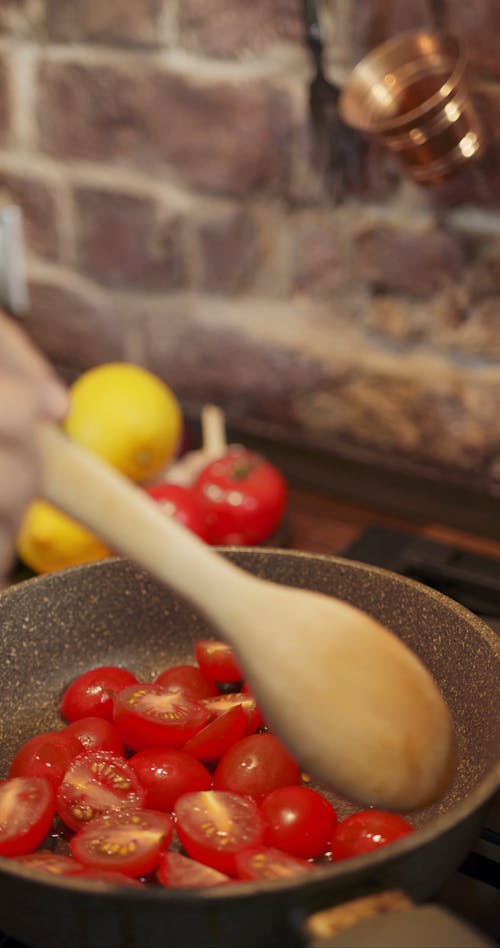 Sauteing Halves Tomatoes On A Hot Pan Of Olive Oil