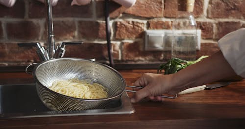 Mixing Newly Cooked Spaghetti Noodles With Sauce