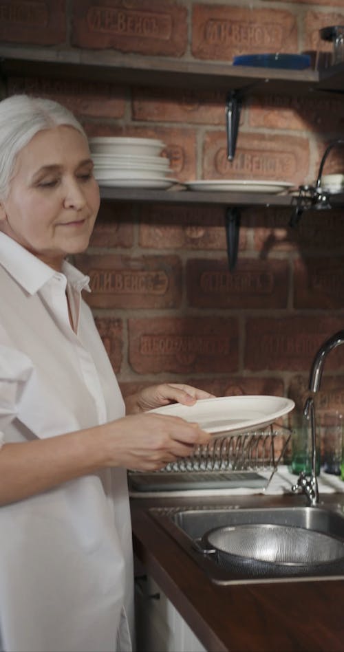 An Elderly Cooked Checking The Spaghetti Noodles Softness