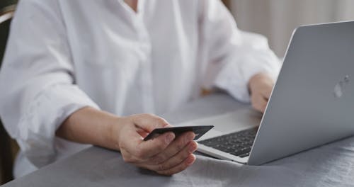 A Woman Doing An On-line Transaction With His Card Using A Laptop