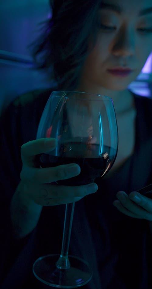 A Woman Drinking A Glass Of Red Wine