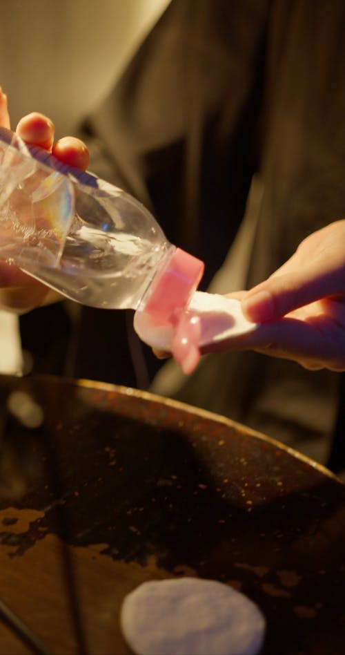 A Woman Removing Her Makeup With Sponge And Micellar Water