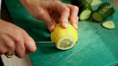 A Person Slicing A Lemon