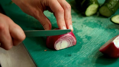 A Person Slicing an Onion
