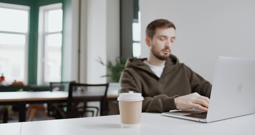 A Man Working With A laptop In A Home Office Set-up