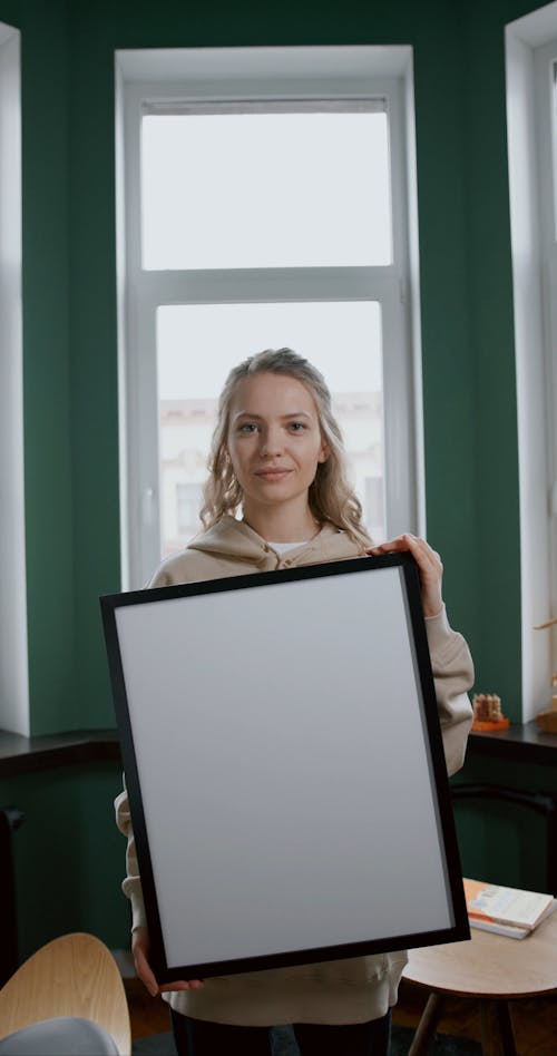 A Woman Holding A Frame With Blank Image