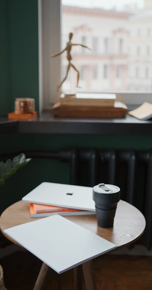 Office Materials And A Cup Placed On Top Of A Wooden Table