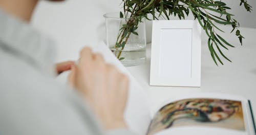 A Man Looking At Pictures In A Book