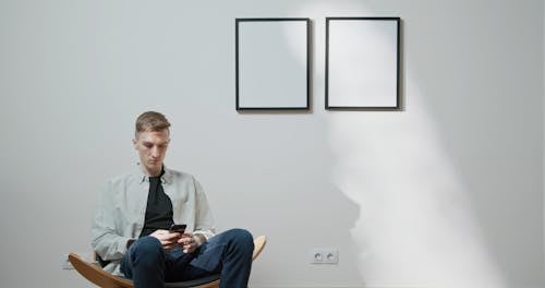 A Man Using His Cell[hone While Seated In A Customize Chair