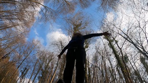 A Woman With Arms Spread Shouting In The Forest