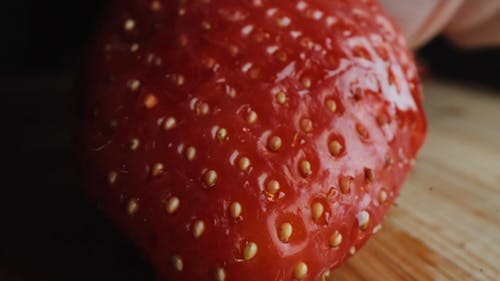 Person Slicing A Strawberry In Close-up View