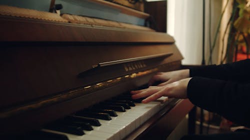 A Man Playing Music With A Piano