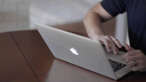 A Person Typing on his Laptop