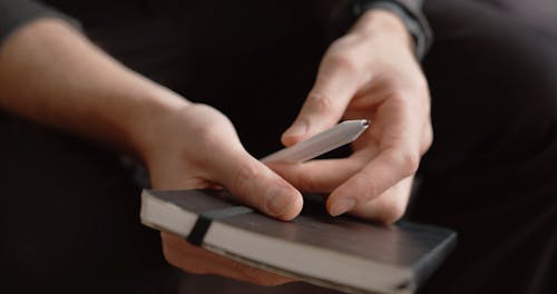 A Person Looking At His Notebook Planner