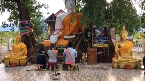 Praying To Buddha Statues Under A Tree