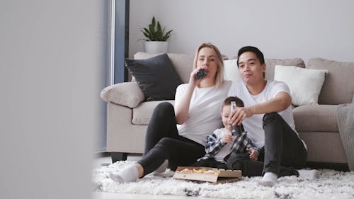 A Family Having Pizza And Bottled Soda For Food While Staying At Home