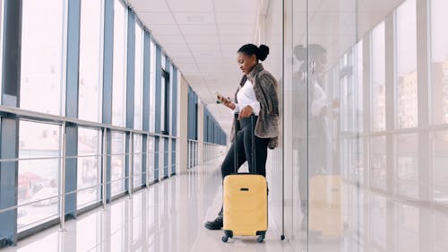 A Woman With A Luggage Talking On Her Mobile Phone