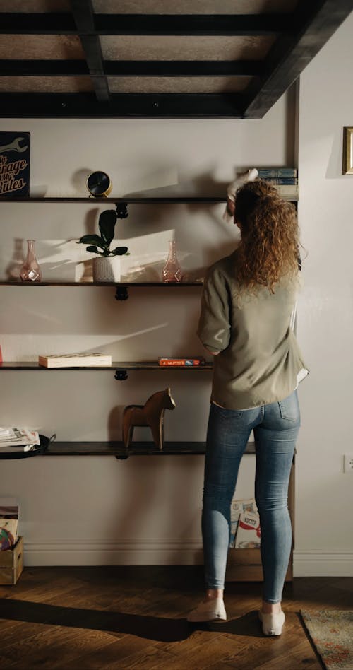 A Woman Cleaning The Shelves And Its Contest While Dancing