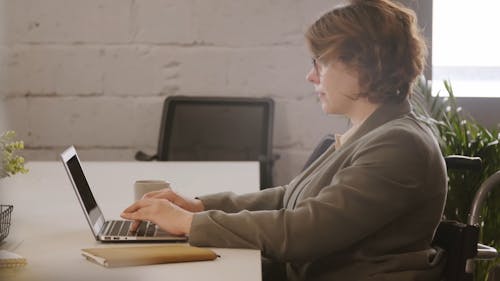 Woman in Wheelchair Using Her Laptop