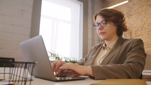 A Woman Typing in her Laptop