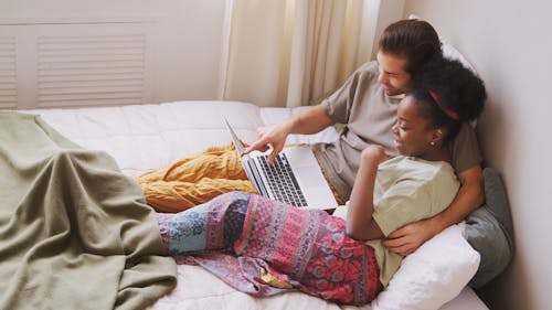 Couple In Bed With a Laptop