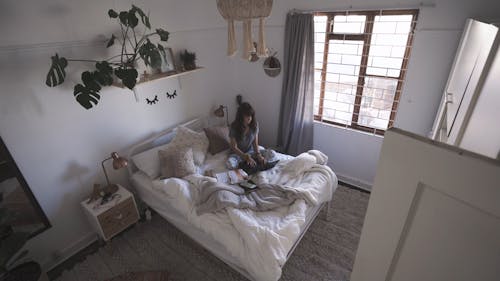 A Woman Typing on Laptop in the Bedroom