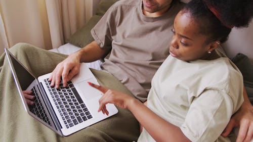 A Couple Discussing Work Using A Laptop While Staying Home 