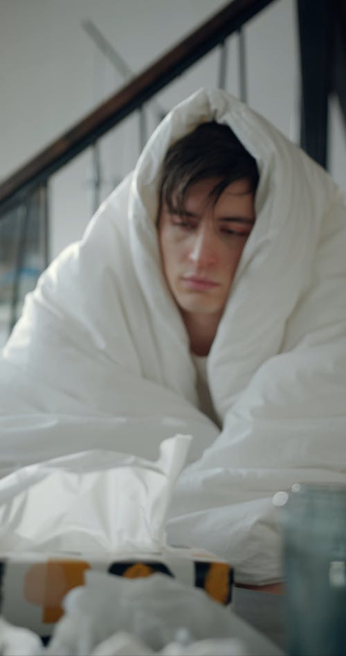 A Sick Man Cover Himself With A Thick Blanket