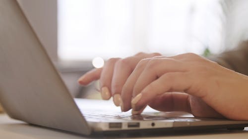 A Person Typing On A Laptop Keyboard