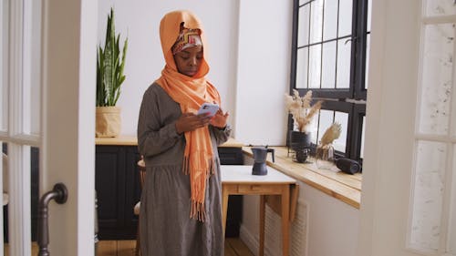 A Woman Texting On Her Phone While At Home