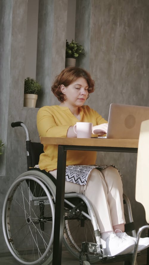 A Woman on a Wheelchair Using a Laptop