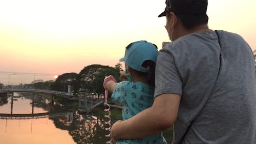 A Father And Daughter Enjoying The Outdoor Environment At Sunset