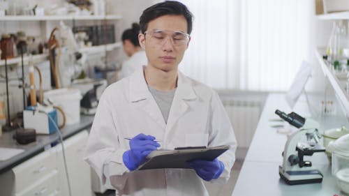 A Man in the Laboratory Holding a Clipboard