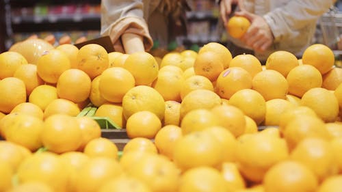 People Buying Oranges In A Grocery Store