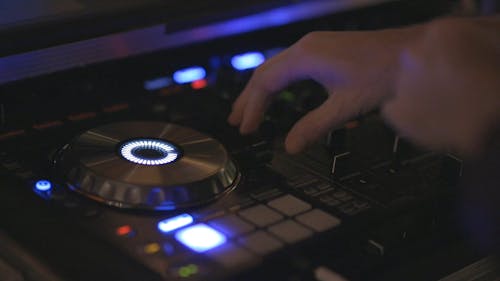 A Disc Jockey Mixing Music With His Equipment