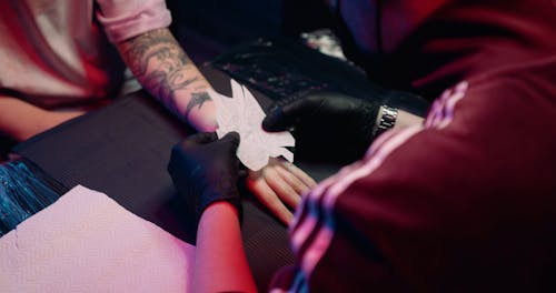 Transferring The Dragon Design On A Customer Hand For Tattooing