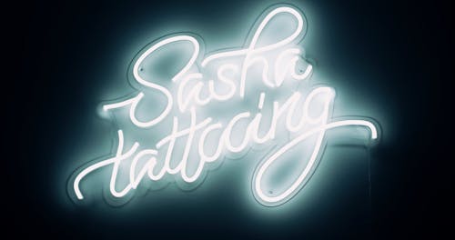 A Lighted Signage Of A Tattoo Shop