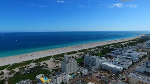 Aerial Shot Over the City on Coastal Line with White Sand Beach