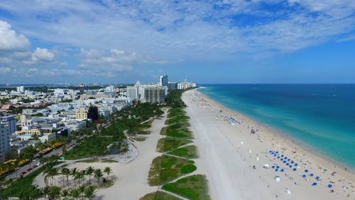 Aerial Shot Over the City on Coastal Line with White Sand Beach