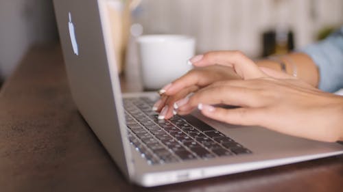 A Woman Typing On Her Laptop