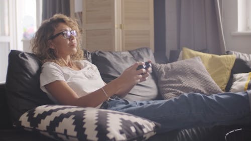 A Woman Playing A Video Game Using A Remote Control